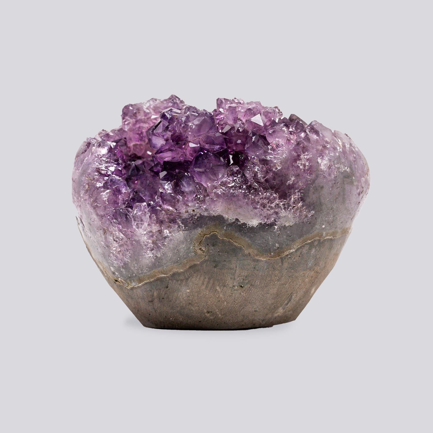 Mini amethyst geode with sparkling purple quartz crystals, visible agate banding, and a polished base in a compact sculptural form.