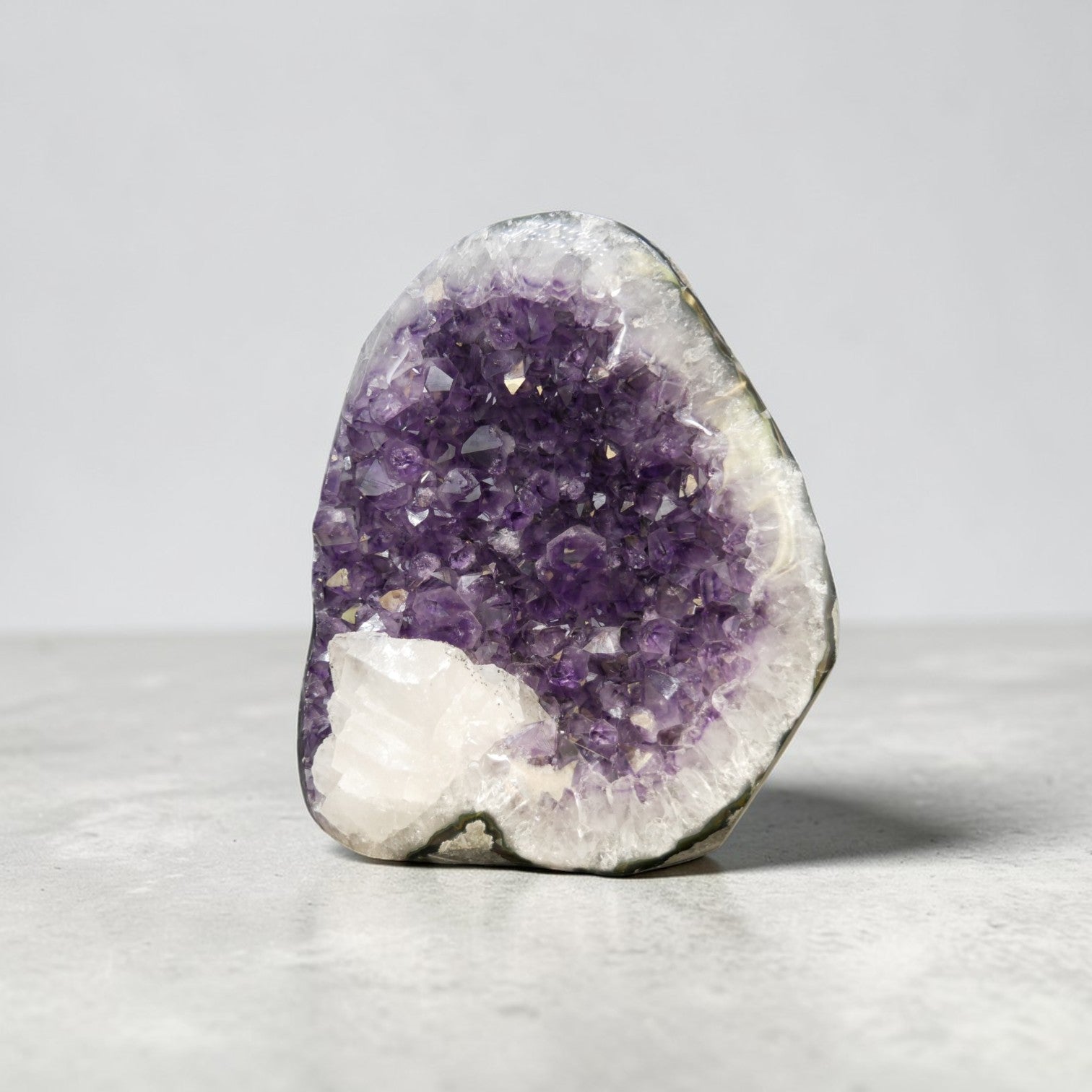 Natural amethyst geode with large white calcite crystal growth inside cavity, dual mineral formation, Artigas Uruguay