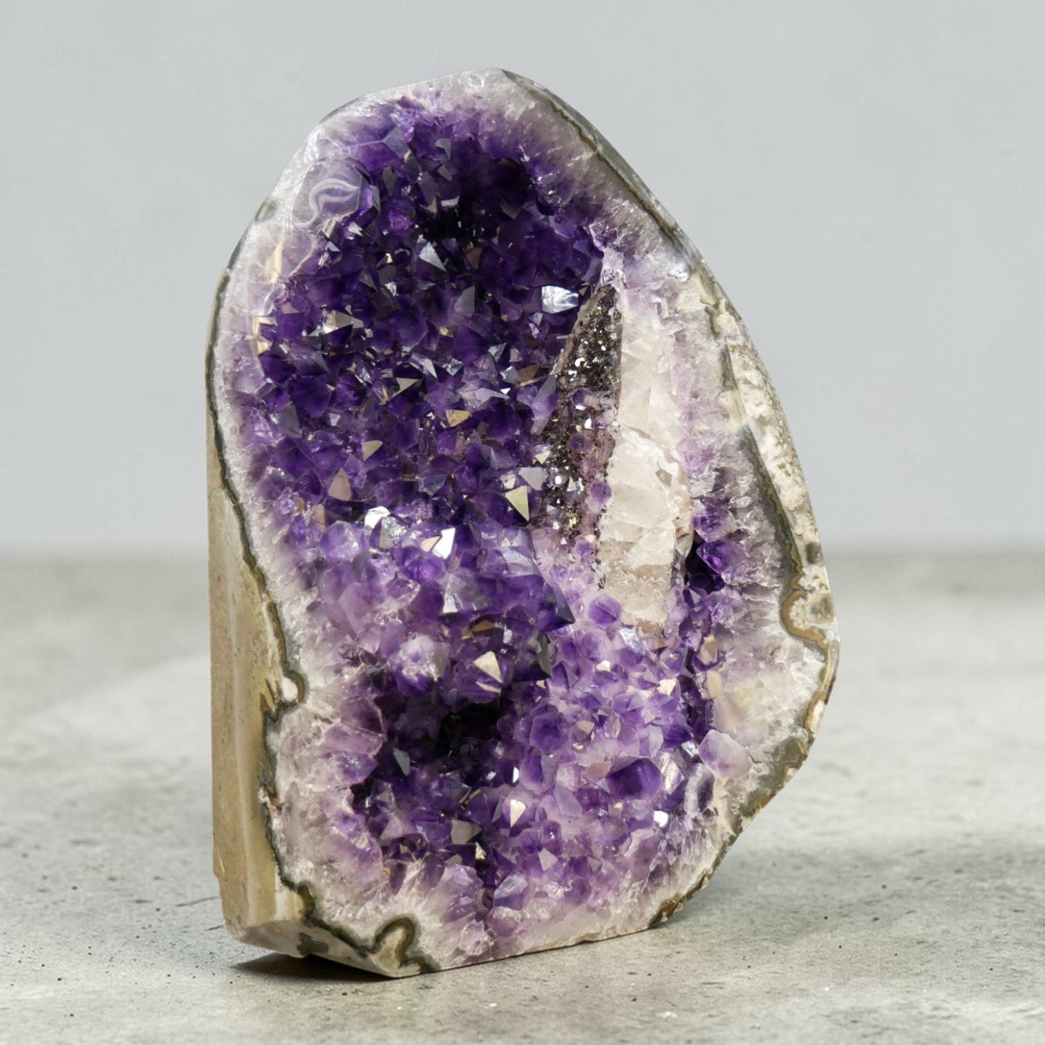 Deep purple amethyst cluster 33.95 lb AAA grade, natural open formation with white quartz border, ethically sourced from Artigas Uruguay, self-standing on wooden table