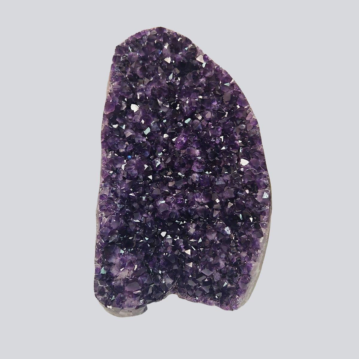 Huge deep violet Uruguayan amethyst cluster standing upright in natural light, featuring dense sparkling crystal points