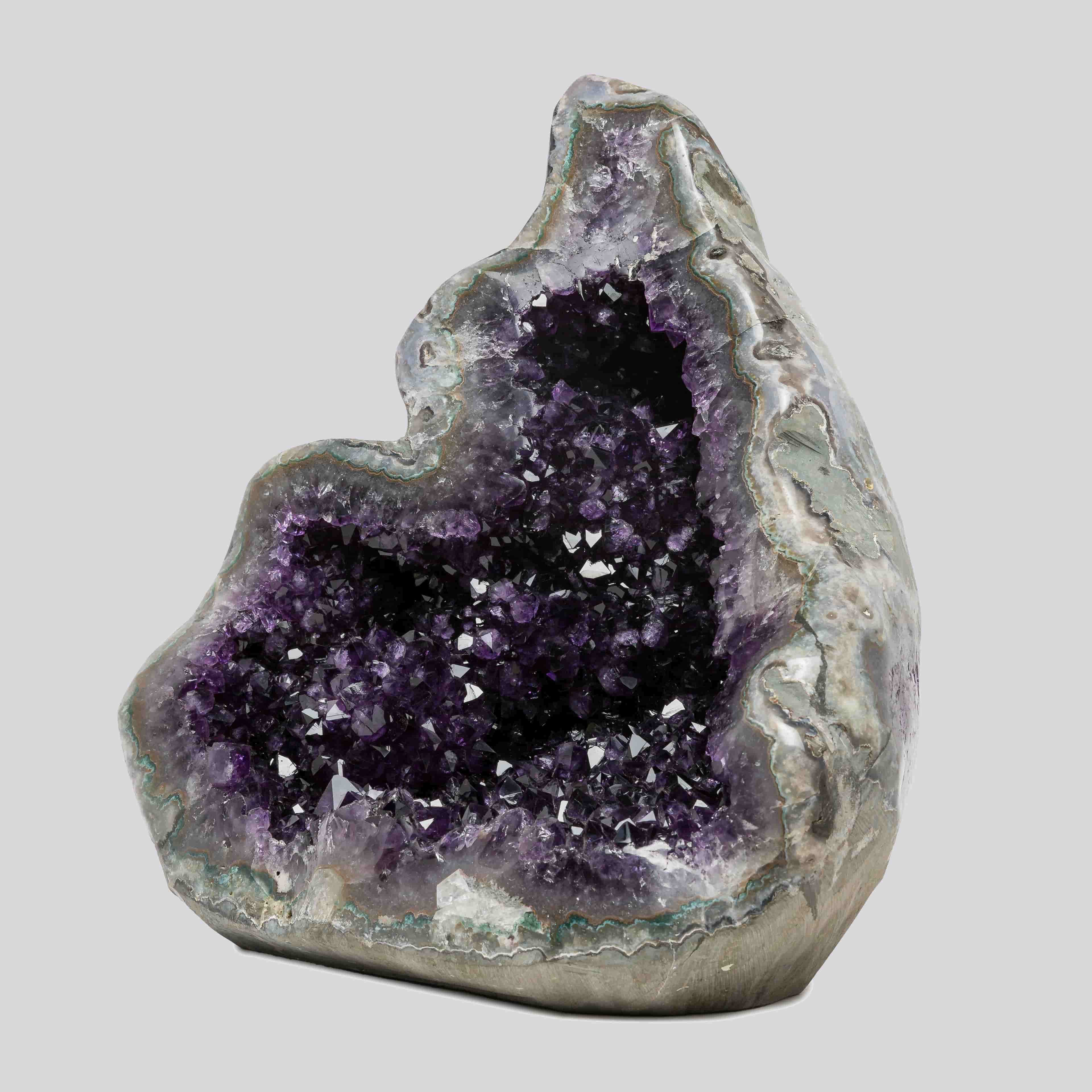 Deep purple Uruguayan amethyst geode with a dark crystal cavity and layered quartz banding, ideal for refined home decor.